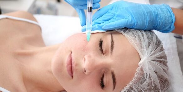 Eine Kosmetikerin führt eine Gesichtshautverjüngung mit Plasma durch